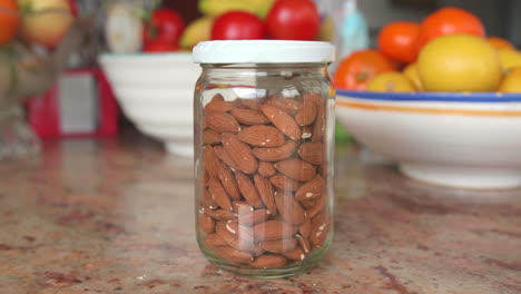 Bulk-unshelled-almonds-in-a-glass-jar-on-a-kitchen-table