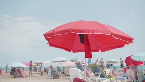 Roter-Sonnenschirm-Und-Stühle-Auf-Dem-Weißen-Sand---Tropischer-Strand-Mit-Touristen-Im-Sommer---Statische-Aufnahme
