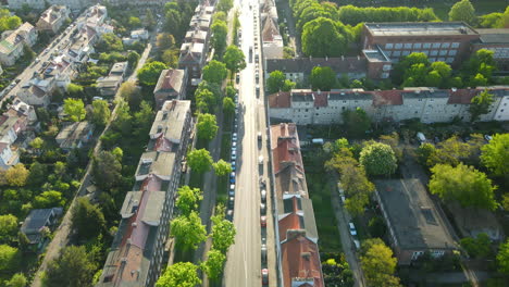 Aerial-View-of-Residential-District-and-Line-of-Cars-Parked-in-the-Street-Along-the-Buildings-in-Gdansk-on-Sunset,-tilt-up-revealing-shot