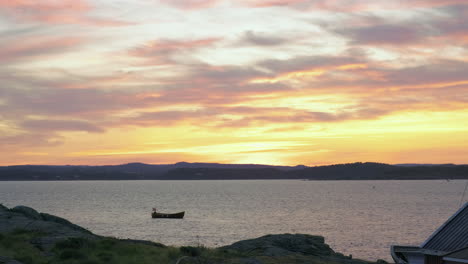 Vögel,-Die-Während-Des-Goldenen-Sonnenuntergangs-In-Der-Stadt-Arendal,-Norwegen,-über-Das-Kleine-Boot-In-Der-Nähe-Der-Insel-Store-Torungen-Fliegen