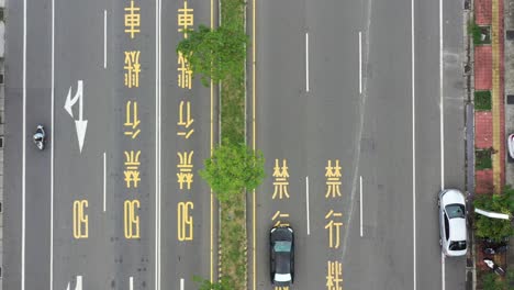 Aerial-Drone-Footage-of-Zoom-Out-Bird-Eye-View-of-Asphalt-Road-and-Traffic-in-Taiwan-with-Chinese-words-signage-of-speed-limit-50-and-motorcycle-is-prohibited-painted-on-the-road
