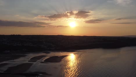 Goldene-Himmlische-Sonnenuntergangsstrahlen-Luftaufnahme-Reflektiert-über-Romantische-Exotische-Strandküstenlinie-Langsam-Umkehrender-Schuss