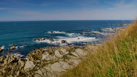 Beautiful-coastline-from-Kaikoura-during-sunny-day-with-rocky-shore-and-crashing-waves-from-the-ocean