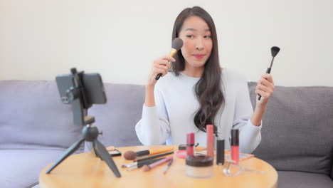 A-young-female-YouTuber-films-her-makeup-tutorial-with-her-smartphone-and-tripod