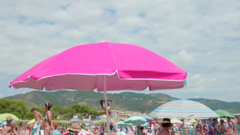 Close-Up-Of-Pink-Beach-Umbrella-At-The-Sea-Coast-Under-The-Sun-In-Summer