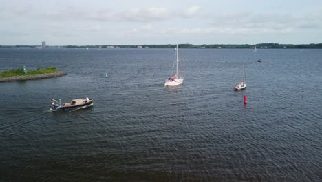 Aerial-view-of-pleasure-boats-departing-from-the-harbor-and-sailing-onto-the-lake-of-Gooimeer