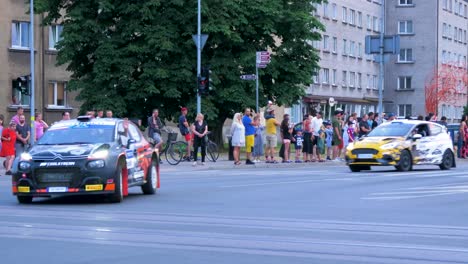 FIA-European-Rally-Trophy-2021-festive-start-and-cars-parade-at-streets-of-Liepaja-,-rally-cars-passing-spectators,-medium-angle-tracking-shot