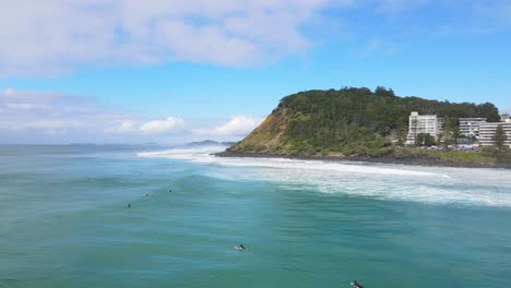 Surfers-At-The-Beach-With-The-Famous-Burleigh-Heads-In-Australian-City-Of-Gold-Coast-At-Daytime