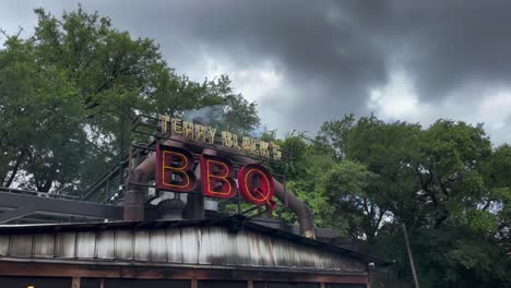 Pedestal-Shot-of-Smoke-Emitting-from-Terry-Blacks-Texas-BBQ-on-a-Cloudy-Day-in-Austin,-Texas