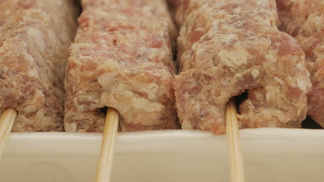 Close-up-View-Of-Uncook-Mititei-On-Skewers---Romanian-Cuisine