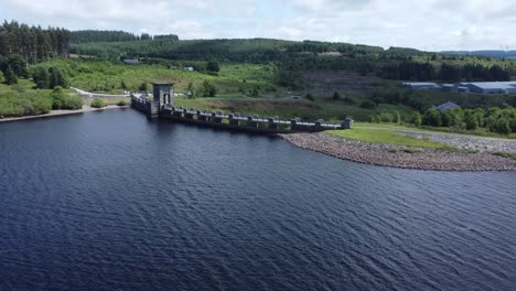 Alwen-reservoir-Welsh-woodland-lake-water-supply-aerial-view-concrete-dam-countryside-park-orbit-wide-right-push-in