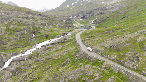 Vehículo-Que-Viaja-En-Un-Camino-Estrecho-Por-Las-Laderas-Rocosas-De-Trollstigen,-Noruega---Toma-Aérea