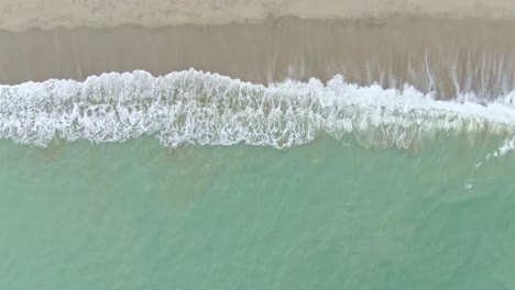 Looking-down-a-calming-view-of-crashing-waves-through-the-sandy-seashore