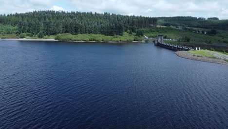 Alwen-reservoir-Welsh-woodland-lake-water-supply-aerial-view-concrete-dam-countryside-park-wide-descend-to-lagoon