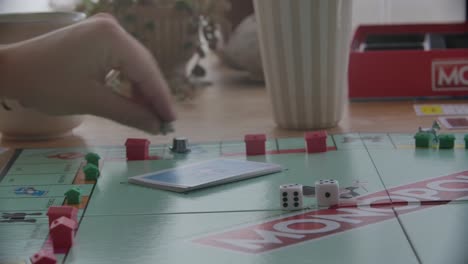 Close-up-view-of-a-person-throwing-the-dices-in-a-game-of-Monopoly,-filmed-handheld-in-4k