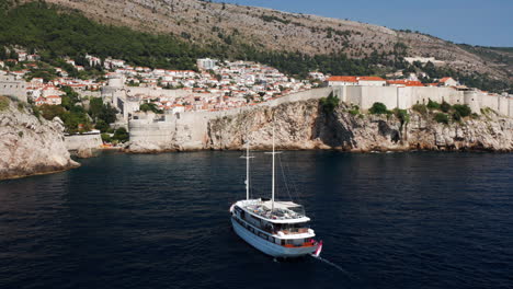 Pleasure-Boat-Cruising-At-Adriatic-Sea-Near-Walls-of-Dubrovnik-in-Croatia