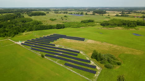 Aerial-drone-flight-over-beautiful-green-landscape-and-modern-solar-panel-farm---Production-of-renewable-and-environmental-energy
