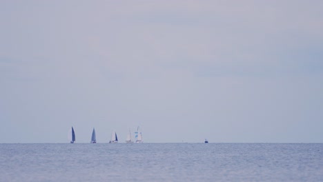 Distant-View-Of-Sailboats-On-A-Serene-Ocean-During-Sunny-Day
