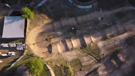 Ariel-view-of-one-person-cycling-on-dirt-racing-track-with-his-BMX-bicycle-at-sunset