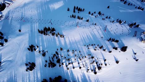 Vista-Aérea-Del-Remonte-Al-Pie-De-La-Pista-De-Esquí-Con-Una-Multitud-De-Esquiadores-Y-Snowboarders