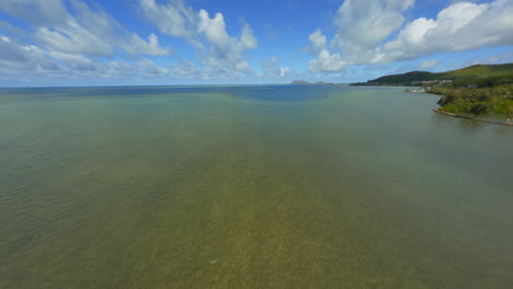 Fliegen-über-Kaneohe-Bay,-Fpv-Drohne-über-Dem-östlichen-Oahu-Ufer-Von-Kaneohe,-Kailua,-An-Einem-Sonnigen-Sommertag-Mit-Flauschigen-Wolken-Darüber-Und-Booten-Im-Wasser