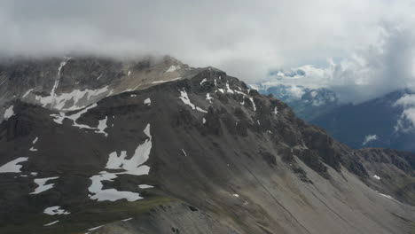 Aerial-of-mountain-top-with-thawing-snow-on-rocks