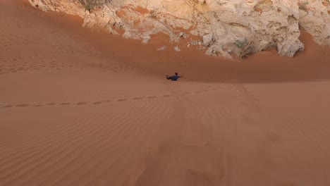 Männlicher-Touristischer-Sand,-Der-Unten-Wüstendüne-In-Dubai-Einsteigt