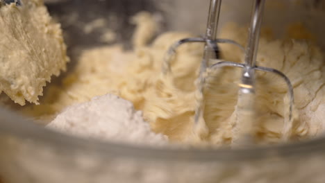 Creamy-delicious-batter-with-butter-and-eggs-being-mixed-in-a-bowl---isolated-close-up-in-slow-motion