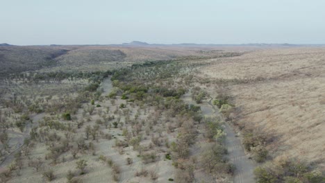 Cinematic-Aerial-View-Over-Dry-Riverbed,-Etosha-National-Park,-Namibia