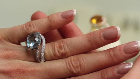 Woman-hand-trying-on-expensive-jewellery-rings-at-the-jewel-store,-luxury-jewelry-close-up,-diamond,-aquamarine,-sunela