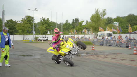 Stunt-Driver-Gestures-Thumbs-up-While-Performing-Side-Wheelie-Trick-On-A-Quad-Bike