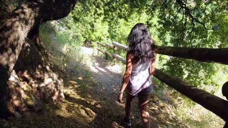 Woman-Walking-In-A-Forest-Path-In-Beautiful-Quiet-Landscape---following-shot