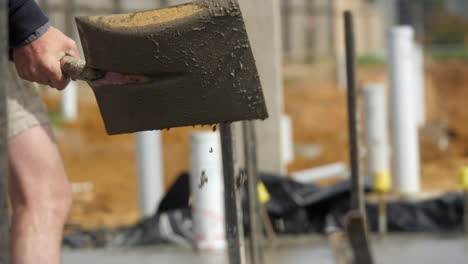 CLOSE-UP-Wet-Cement-Flicked-Off-Shovel-Onto-Newly-Laid-House-Slab