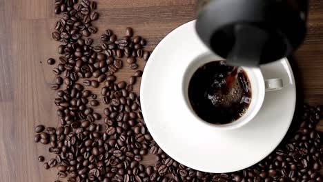 Tasse-Heißen-Schwarzen-Kaffee-Auf-Einem-Tisch-Mit-Kaffeebohnen-Auf-Einem-Tischvideo