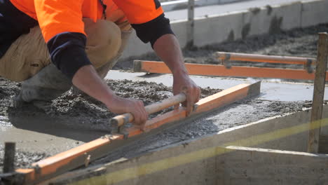 Construction-Worker-Levelling-Wet-Cement-With-Trowel-At-Slab-Pour-Site