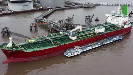 Silver-Rotterdam-chemical-oil-tanker-ship-with-support-loading-at-Tranmere-terminal-Liverpool-aerial-view-orbit-left
