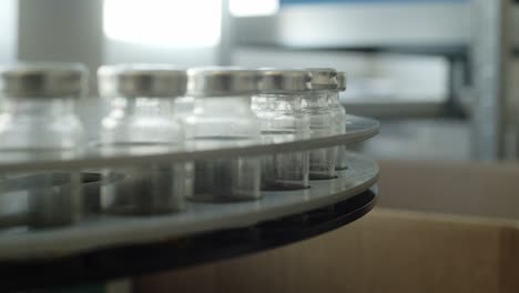 Glass-vials-with-a-metal-cap-on-a-metal-carousel-in-the-testing-laboratory
