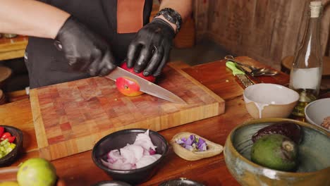 A-male-professional-culinary-chef-cutting-and-peeling-fresh-mango-on-a-chopping-board,-preparing-ingredients-for-appetizer