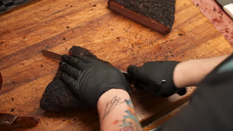 Overhead-view-of-pitmaster-carefully-slicing-perfectly-smoked-Texas-beef-brisket-into-portions,-slow-motion-close-up-4K