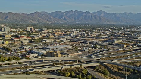 Salt-Lake-City-Utah-Aerial-v23-pan-shot-capturing-traffic-crossing-on-complex-highway-with-downtown-cityscape-and-beautiful-mountainscape-background---Shot-with-Inspire-2,-X7-camera---October-2021
