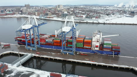 A-crane-unloads-a-cargo-container-ship-in-the-port-of-Saint-John,-New-Brunswick