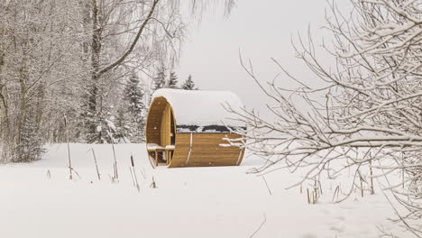 Thermowood-barrel-sauna-isolated-on-snow-covered-field