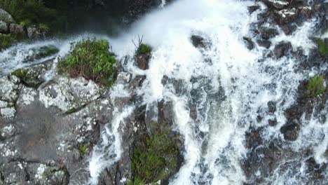 Unique-view-following-a-fast-flowing-creek-bed-as-it-drops-quickly-over-a-majestic-waterfall