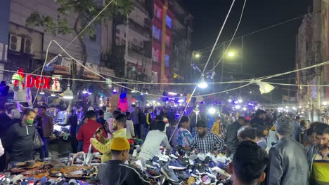 Night-open-air-shoe-market-with-crowded-people-in-an-urban-city