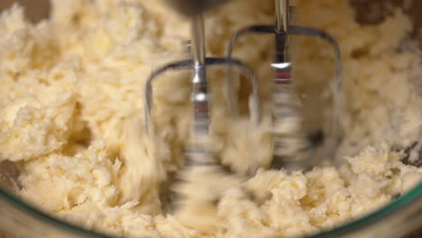 Mixing-some-of-the-dry-ingredients-with-butter-to-make-cake-batter---close-up-isolated-view
