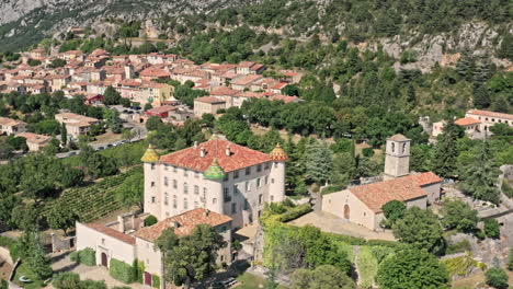 Aiguines-France-Aerial-v1-low-level-drone-flying-around-french-castle,-chateau-de-la-palud-sur-verdon-capturing-village-townscape-and-scenic-landscape---July-2021