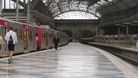 Passagiere,-Die-Während-Der-Neuartigen-Covid-19-pandemie-In-Lissabon,-Portugal,-Auf-Dem-Bahnsteig-Spazieren-Gehen,-Während-Sie-Den-Zug-Am-Bahnhof-Rossio-Betrachten