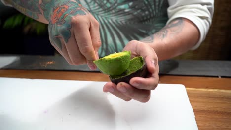 Chef-taking-out-avocado-from-peel-to-cutting-table-slow-motion
