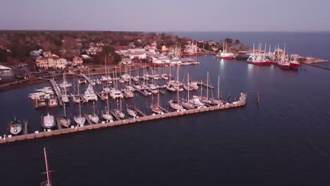 sunset-aerial-oriental-nc,-north-carolina-with-sailboats,-fishing-boats-and-shrimp-boats-in-foreground