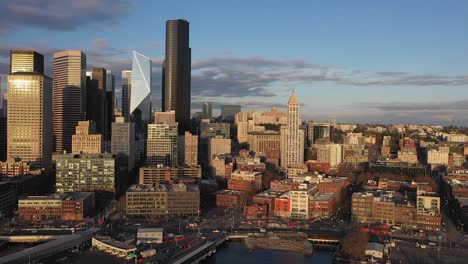 Drone-shot-of-Seattle's-waterfront-near-Pioneer-Square-at-sunset